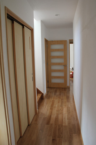 １階廊下 トイレの入り口は３枚引き戸で開口部を広く取っています。 正面は台所へのガラス入りのドア