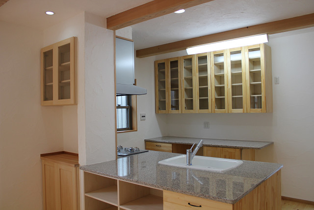 キッチンは無添加住宅のイン松＋石天板で作ったキッチンです。 収納のガラス入り吊り戸棚もイン松の集成材で作っています。